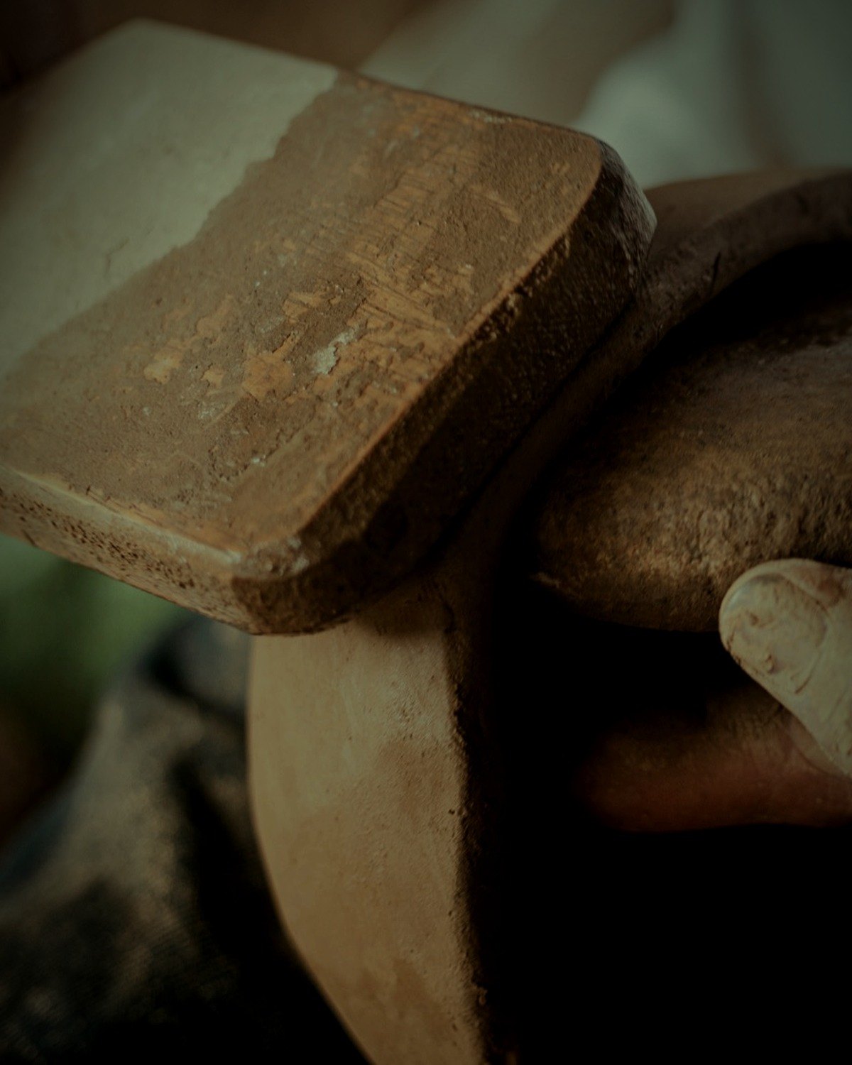 A wooden paddle against the wall, a river stone held inside