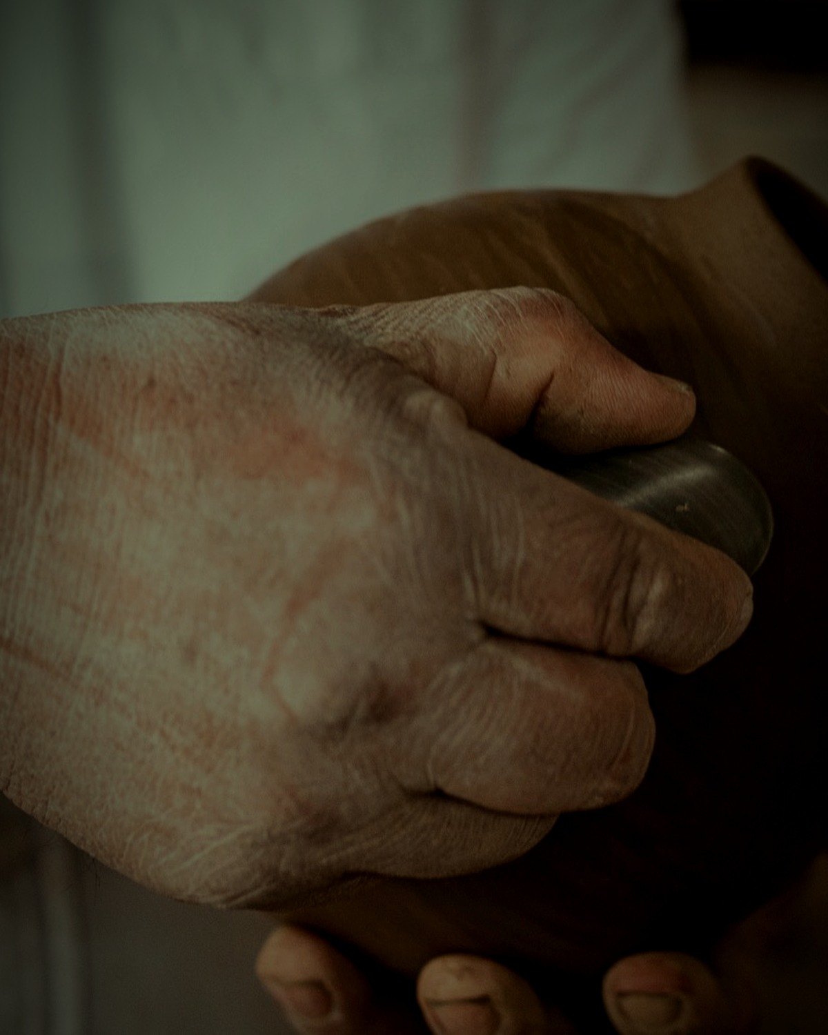A stone burnishing the surface of a leather-hard vessel